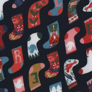 Może przedstawiać: Tkanina w kolorze granatowym z powtarzającym się wzorem kolorowych skarpet. Każda skarpeta ma inny wzór, w tym kwiaty, ptaki i kształty geometryczne. Skarpety są ułożone w diagonalny wzór.