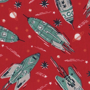 May include: Red fabric featuring a repeating pattern of teal, grey, and red retro-style rockets. The design includes white stars, planets, and comet trails, creating a space-themed pattern.