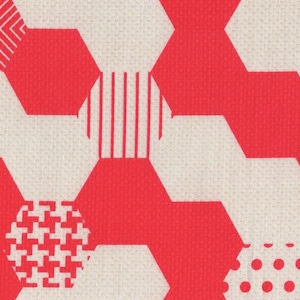 Op de afbeelding: Een naadloos patroon van rode en witte zeshoeken met verschillende geometrische ontwerpen in elke zeshoek. De achtergrond is lichtbeige.