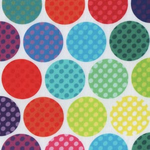 Op de afbeelding: Een stofpatroon met grote, kleurrijke stippen op een witte achtergrond. De stippen zijn in verschillende kleuren, waaronder rood, blauw, groen en paars, elk met kleinere stippen erin.