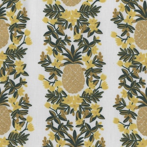 Może przedstawiać: Biała tkanina z powtarzającym się wzorem złotych ananasów i żółtych kwiatów. Ananasy otoczone są ciemnozielonymi liśćmi.