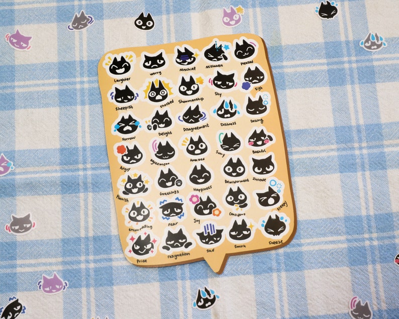 May include: A sheet of black cat stickers with different facial expressions. The expressions include laughter, worry, mischief, nervousness, shy, big, sheepish, excited, showmanship, sorrow, delight, disagreement, distress, daring, angry, annoyance, home, sorry, beautiful, flourish, greetings, happiness, smiling, fear, joy, enjoying, pride, resignation, sad, smirk, surprise.