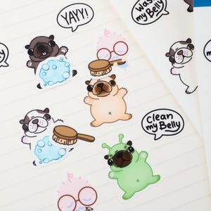 May include: A sheet of stickers featuring cartoon pugs in various poses. Some pugs are brown, others are white and black, and one is green. Speech bubbles say "Wash my Belly", "Clean my Belly", and "YAYY!"