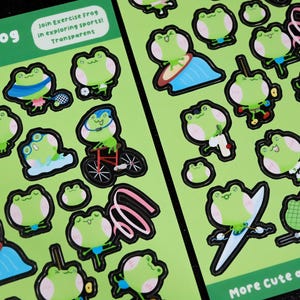 May include: Two sheets of green stickers featuring cartoon frogs engaged in various sports. The stickers include frogs playing tennis, riding a bicycle, and jumping rope. Text on the stickers reads "Sporty Frog Stickers".
