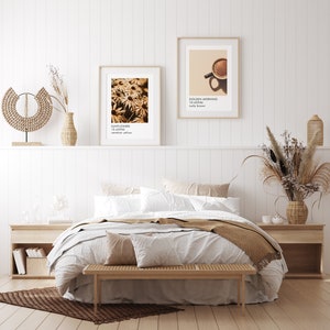 May include: A white bed with a brown blanket and a wooden bench in front of it. There are two framed prints on the wall behind the bed, one with a sunflower image and the other with a coffee cup image. The text on the prints reads "Sunflowers 10-43950 vermillion yellow" and "Golden Morning 10-45946 nutty brown".