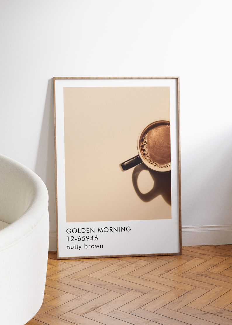 May include: A framed poster with a photo of a cup of coffee with a brown background. The text on the poster reads "GOLDEN MORNING 12-65946 nutty brown".