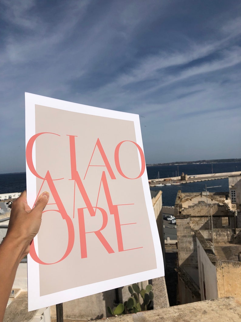 May include: A white poster with a beige background and the text "CIAO AMORE" in pink.