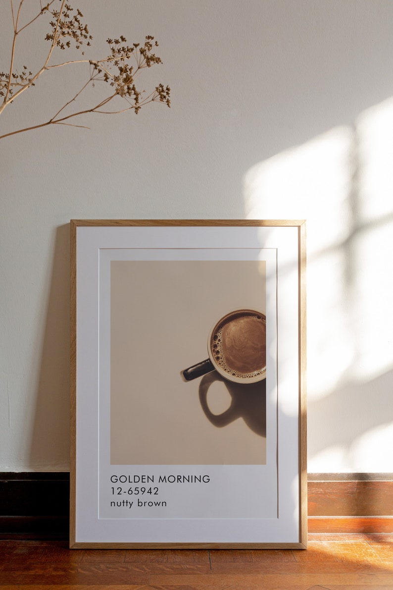 May include: A framed print with a photo of a cup of coffee. The text on the print reads "GOLDEN MORNING 12-65942 nutty brown".