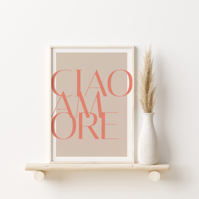May include: A framed print with a beige background and the text "CIAO AMORE" in coral pink.