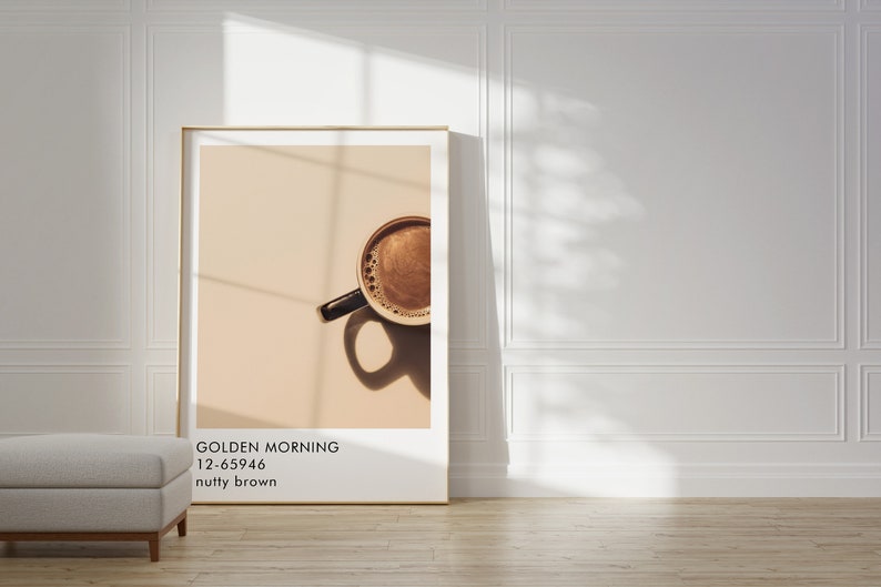 May include: A framed print of a coffee cup with a light brown background. The text on the print reads "GOLDEN MORNING 12-65946 nutty brown".