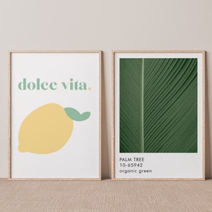 May include: Two framed prints, one with the text "dolce vita." and a yellow lemon illustration, the other with a close-up of a green palm leaf with the text "PALM TREE 10-65942 organic green"