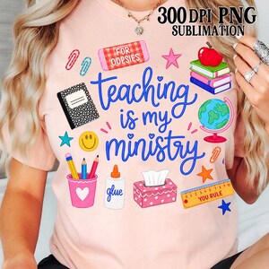 May include: A light pink t-shirt with the phrase "Teaching is my ministry" in blue script. The shirt features school-themed graphics like a notebook, pencils, a globe, and an apple. The text "300 DPI PNG Sublimation" is at the top.