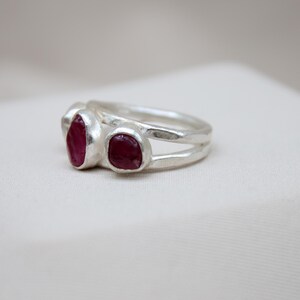 Pu&ograve; includere: Un anello d'argento con tre pietre di rubino rosso incastonate nella fascia.