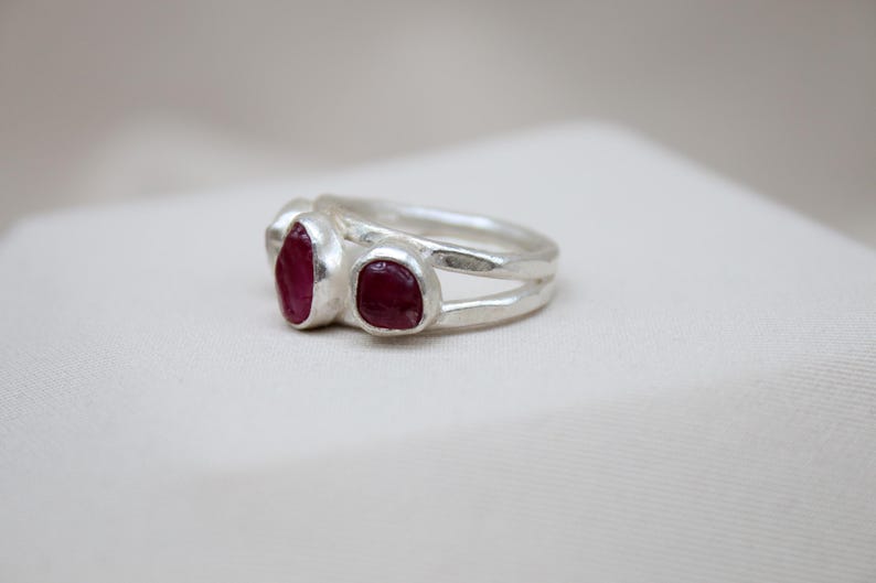 Pu&ograve; includere: Un anello d'argento con tre pietre di rubino rosso incastonate nella fascia.