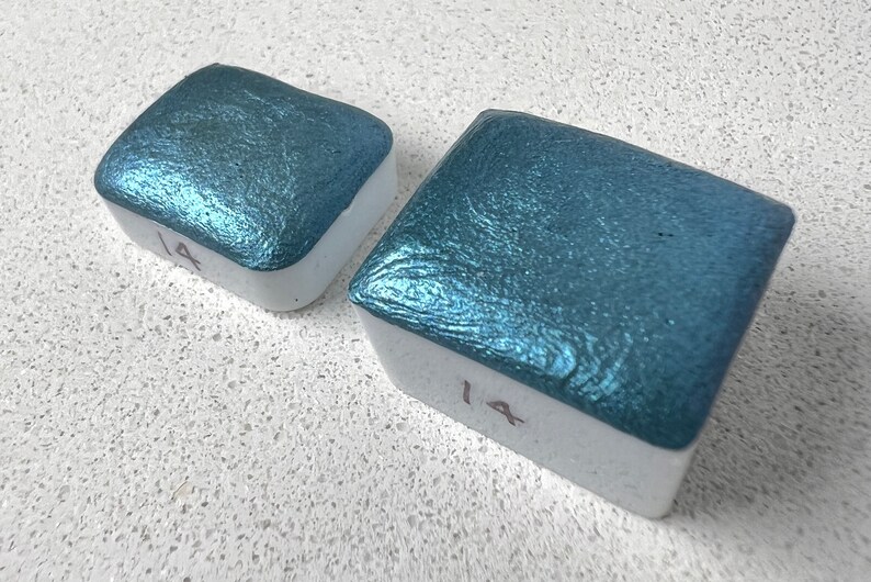 Puede incluir: Dos bandejas cuadradas de pintura acuarela met&aacute;lica azul verdoso. Las bandejas est&aacute;n etiquetadas con el n&uacute;mero "14".