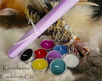 May include: A collection of colorful tea light candles in metal holders, a rolled lavender paper, and a bundle of dried herbs. The candles are in various colors, including black, red, yellow, purple, blue, and white. The text "Kerridwens Cauldron Co." is visible.