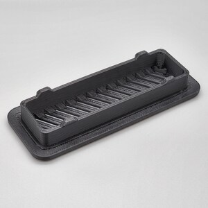 Puede incluir: Una rejilla de ventilaci&oacute;n rectangular de pl&aacute;stico negro con un patr&oacute;n de rejilla. La rejilla de ventilaci&oacute;n est&aacute; dise&ntilde;ada para permitir que el aire fluya a trav&eacute;s de ella mientras evita que los residuos entren.