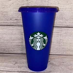 May include: A blue reusable Starbucks cup featuring the Starbucks logo in green and white.