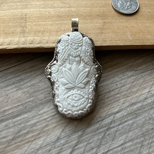 Bone carved hansha pendant made with base metal