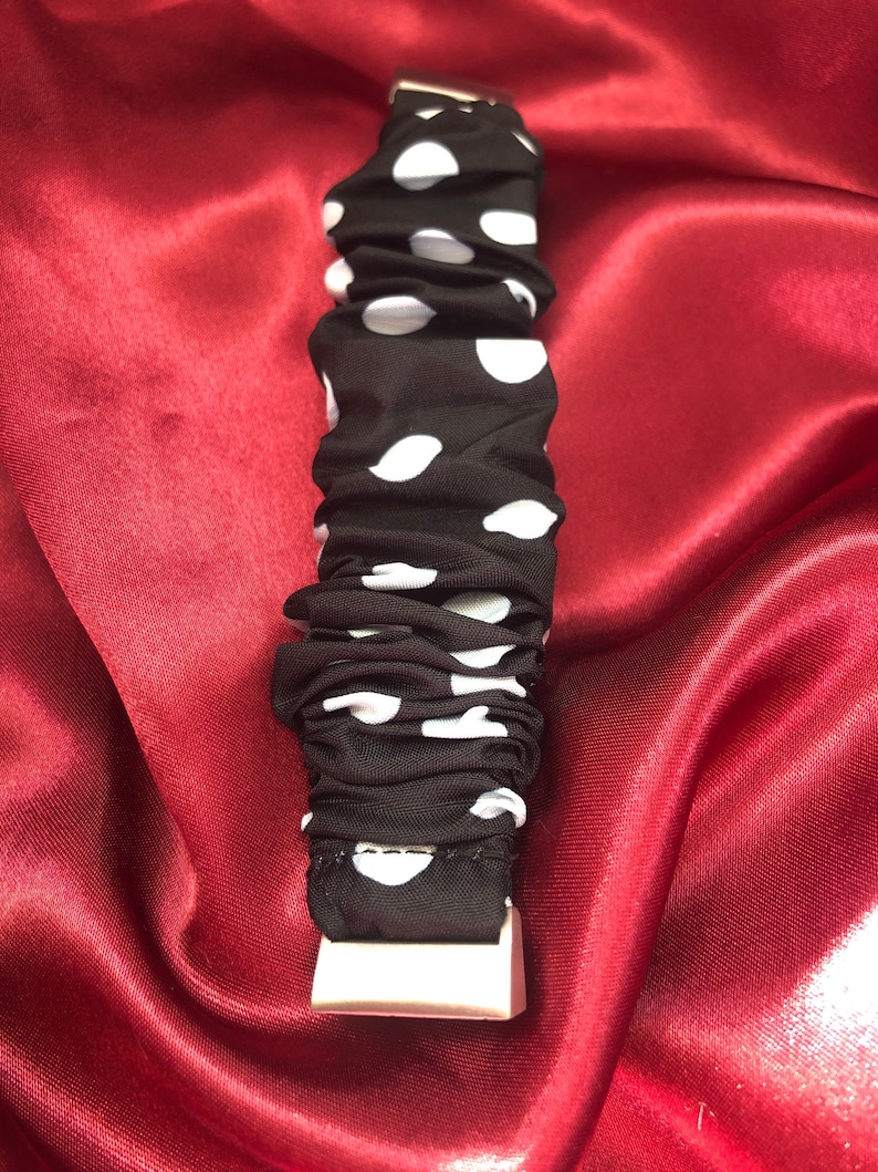 K&ouml;nnte beinhalten: Schwarzes Armband mit wei&szlig;en Punkten und einer wei&szlig;en Schnalle.