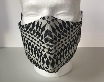 May include: A black and white geometric patterned face mask. The mask is made of a soft, breathable fabric and has a comfortable fit.