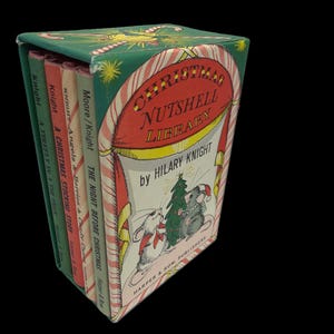 May include: A boxed set of four small books titled Christmas Nutshell Library by Hilary Knight. The green slipcase features a red candy cane archway, two mice decorating a tree, and the title text. The book spines are green, red, cream, and tan.