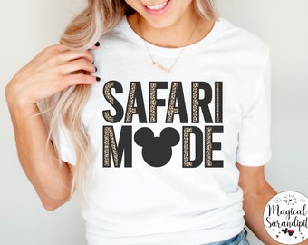 May include: White t-shirt with the text "SAFARI MODE" in black letters outlined with a leopard print pattern. A black Mickey Mouse head is in the middle of the text.