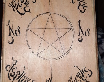 May include: A wooden board with a five-pointed star drawn in the center. The star is surrounded by a circle with a dotted line. The words "Nos" and "Mercies" are written in cursive around the circle. The words "Miser" and "Repenting" are written in cursive at the top and bottom of the board.