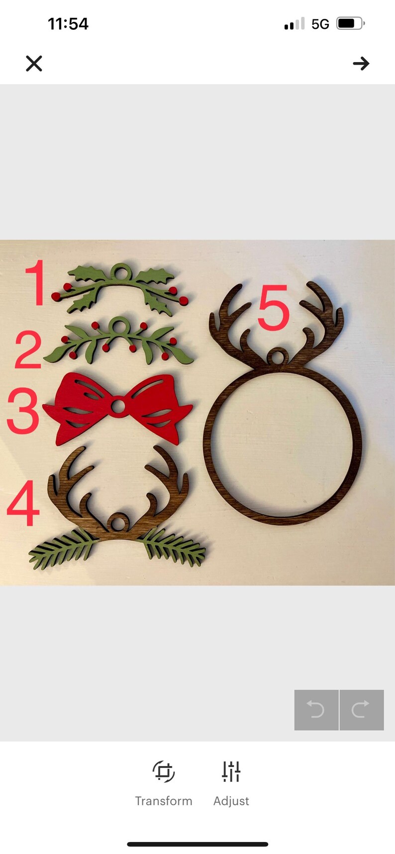 May include: Five wooden Christmas ornaments, including two green holly sprigs, a red bow, and two sets of reindeer antlers. The ornaments are numbered 1 through 5.