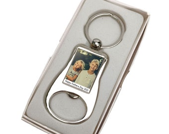 May include: Silver bottle opener keychain with a photo insert. The photo shows two children smiling. The text "Happy Father's Day 2022" is engraved on the bottle opener.