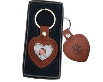 May include: Brown leather heart-shaped keychain with a photo frame and a smaller heart-shaped tag. The tag has the text "Uncle Tom will you be my God Father? Love Willow Rose xxx".