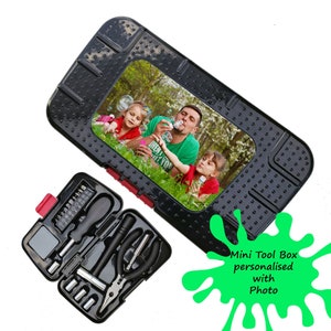 May include: A black tool box with a photo of a family blowing bubbles. The tool box is open and contains a variety of tools, including screwdrivers, pliers, and a wrench. The text "Mini Tool Box personalised with Photo" is written in green on a white background.