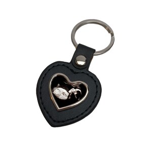 May include: Black leather heart-shaped keyring with a silver frame and a black and white ultrasound image inside.