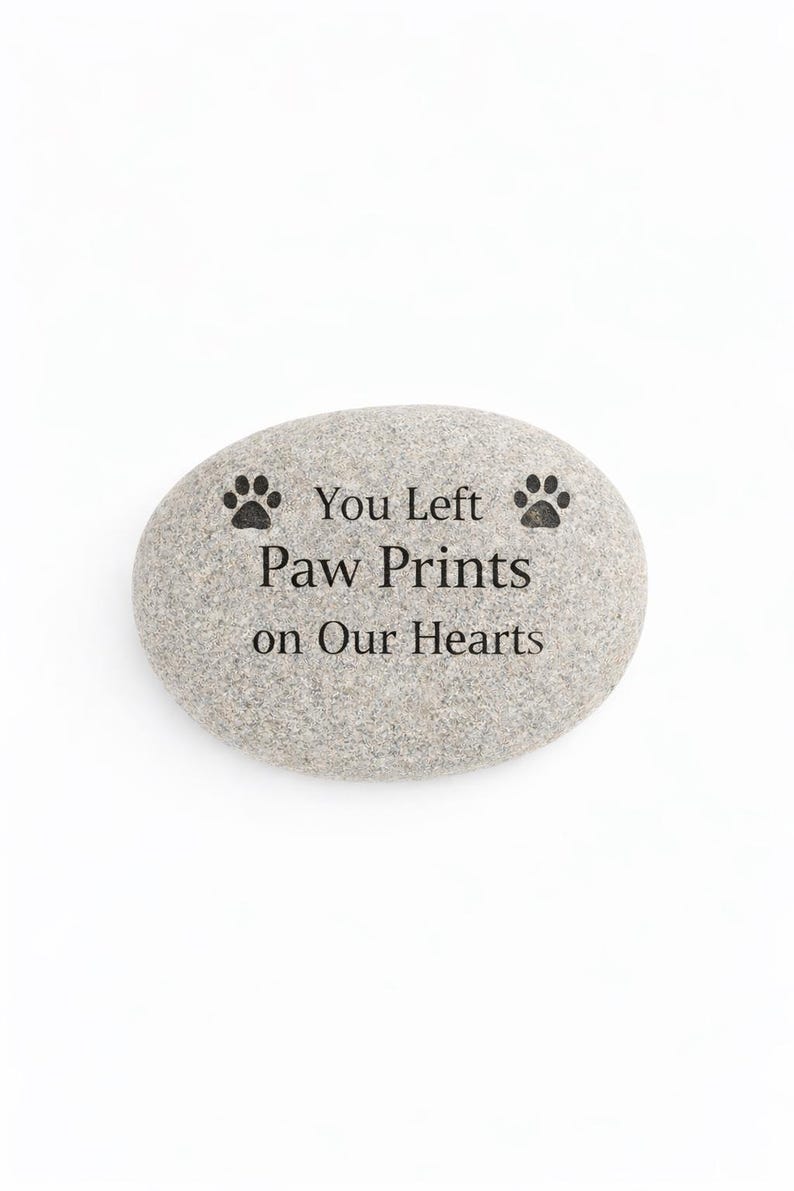 Engraved pet memorial stone with paw print design and message “You Left Paw Prints on Our Hearts” isolated on white background