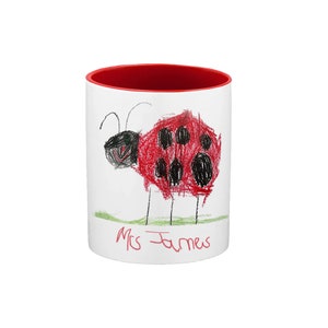 May include: White ceramic mug with a red rim. The mug features a child's drawing of a ladybug with black spots and the text "Mrs. James" at the bottom.