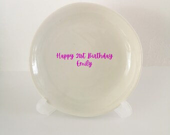 May include: White ceramic plate with the text "Happy 21st Birthday Emily" written in pink.