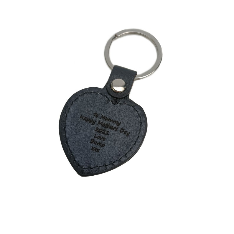 May include: Black leather heart-shaped keyring with a silver key ring. The keyring has the text "To Mummy Happy Mother's Day 2021 Love Bump xxx" engraved on it.