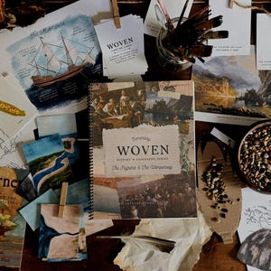 Könnte beinhalten: Eine Anordnung historischer Bücher, Illustrationen und Kunstzubehörs liegt auf einer Holzoberfläche. Im Mittelpunkt steht ein spiralgebundenes Buch mit dem Titel "WOVEN" und dem Untertitel "The Pilgrims & The Wampanoag". Weitere Bücher sind "The Mayflower" und "Quanto's Journey."