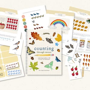 May include: A collection of educational printables for counting, featuring illustrations of butterflies, apples, and a rainbow. The central notebook reads "counting through nature" with a pencil graphic. Other pages show numbers and objects.