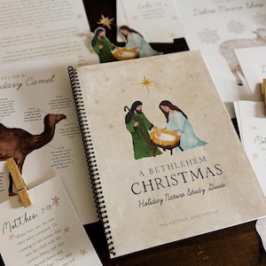 May include: A spiral-bound study guide titled "A Bethlehem Christmas" with illustrations of the nativity scene. Cards and cutouts of a camel, sheep, and biblical text are also present. The guide is for holiday nature study.