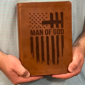 May include: A brown leather-bound journal with an embossed American flag design and the words "MAN OF GOD" on the front cover.
