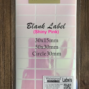 May include: A sheet of 210 bright pink blank labels in three sizes: 30x15mm, 50x30mm, and a 30mm circle. The labels are waterproof, tear-resistant, and easy to write on with a permanent marker. The labels are packaged in a clear plastic sleeve with a label that says "Waterproof Labels Write-On".