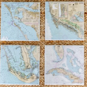 May include: Four nautical maps framed in woven straw mats. The maps are printed in blue and white and show various waterways and islands. The maps are arranged in a grid pattern.