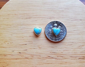 Puede incluir: Un par de pendientes de corazón de turquesa, que se muestran junto a una moneda de diez centavos de dólar estadounidense para comparar el tamaño.