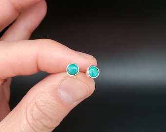 May include: A pair of silver stud earrings with turquoise stones.