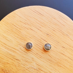 May include: A pair of silver stud earrings with round, dark gray labradorite gemstones.