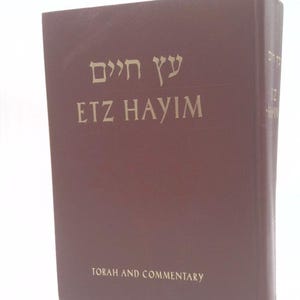 May include: A maroon hardcover book titled Etz Hayim with Hebrew text and the English words Torah and Commentary printed in gold on the front cover. The spine also features the title Etz Hayim in gold lettering against the dark maroon background.