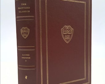 May include: A burgundy leather-bound book with gold accents. The book is titled "The Harvard Classics" and "Sacred Writings 2". The book has a gold embossed Harvard University crest on the front cover.