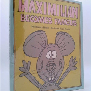 May include: A yellow, blue, and pink book cover with the title "Maximilian Becomes Famous" by Florence Heide, illustrated by Ed Renfro. The cover features a cartoon illustration of a smiling mouse with big ears and outstretched arms.