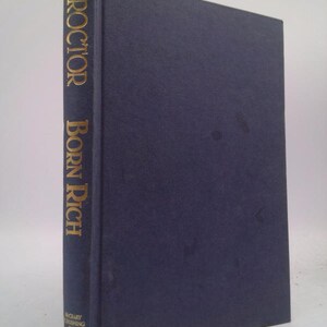 May include: A dark blue hardcover book with the title "PROCTOR BORN RICH" in gold lettering on the spine.